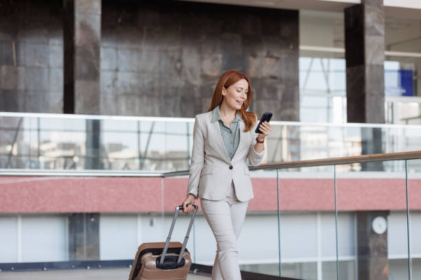 istock Businesswoman using phone at the train station 2176222501