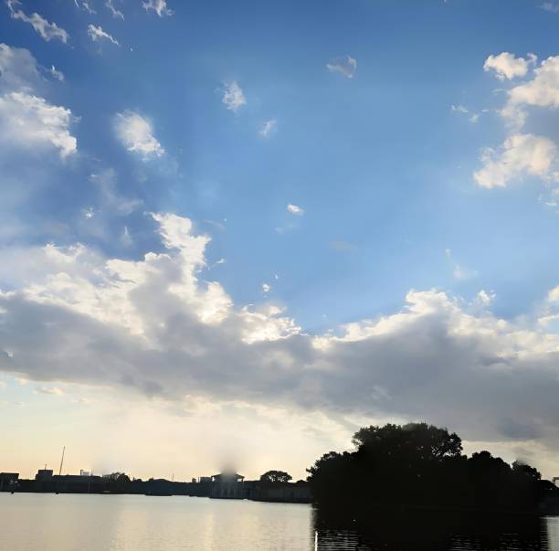 istock Serene lakeside view with blue sky and clouds 2176222653