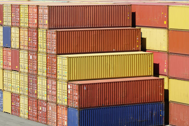Yellow, orange, red and blue shipping cargo containers stacked in several layers at the port terminal, stack of containers in a harbor container terminal