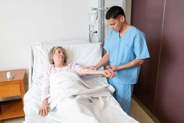 istock Nurse managing IV fluids for elderly woman patient 2176228035