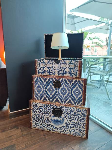 Stylish and Stacked Suitcases Accompanied by Charming Lamp Decor for a More Inviting Ambiance
