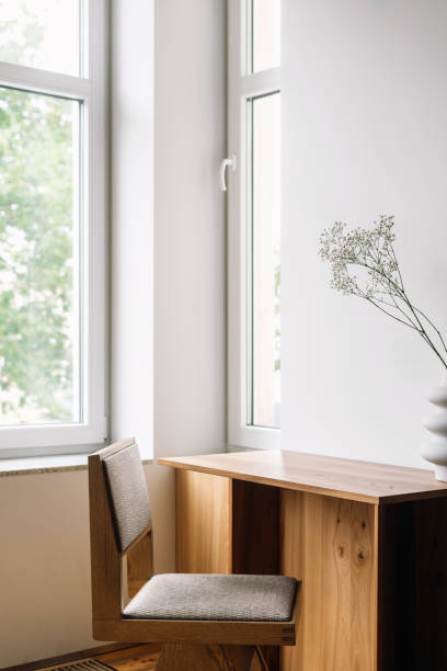 istock A minimalist workspace featuring a wooden desk and chair 2176236417
