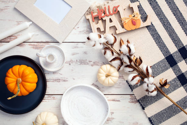 istock Cozy autumn flat lay with white pumpkins, cotton branches, photo frame, and a ‘Hello Fall’ sign on a wooden surface. Perfect for seasonal decor and fall-themed content 2176236684
