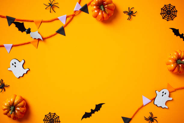 istock Halloween flat lay composition with pumpkins, spiders, ghosts, bunting flag garland on orange background. Happy Halloween banner mockup. 2176238240