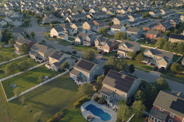 istock Houses with Solar Panels - Modern Middle Class Neighborhood - Dense Population - High Angle - Golden Hour 2176247533