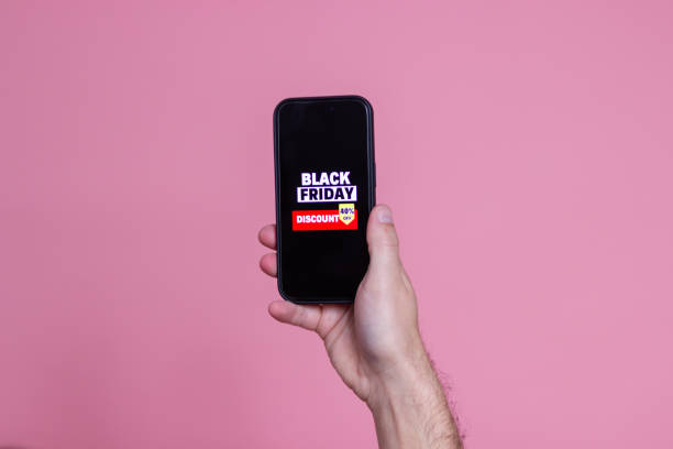 istock Man is holding a smartphone showing black friday discount on the screen 2176247796