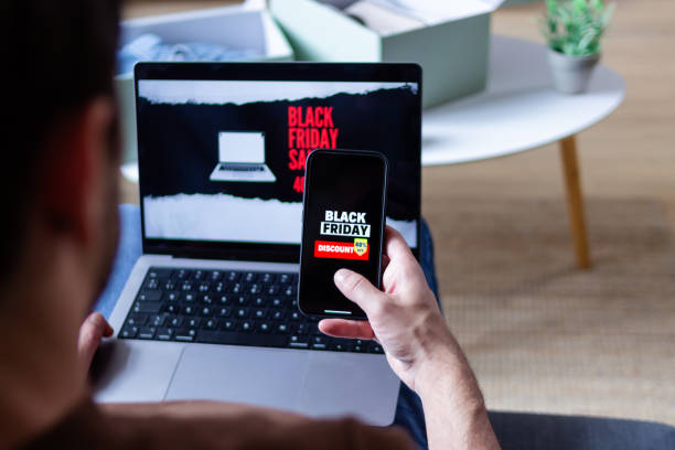 istock Man shopping online using laptop and smartphone during black friday sales 2176248755
