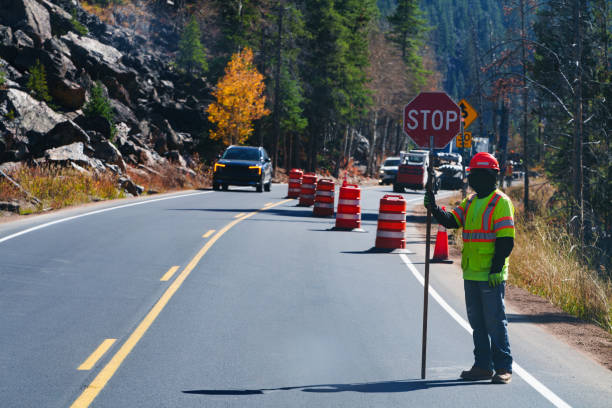 istock Highway Road Worker in Construction Zone Holding Stop Sign 2176257923