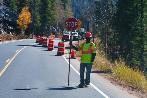 istock Highway Road Worker in Construction Zone Holding Stop Sign 2176257951