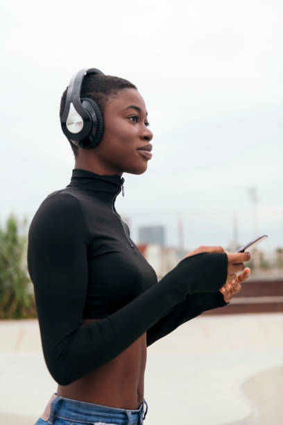 istock ethnic female in wireless headphones using phone 2176267758