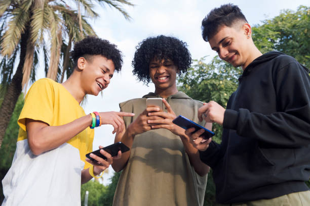 istock teen friends having fun using mobile phones 2176268278