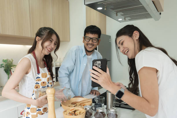 istock Friends enjoy casual conversation and bonding over smartphones in a modern kitchen. 2176290176