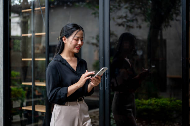 istock A confident businesswoman is replying to chats on her phone while walking through an office corridor 2176291252
