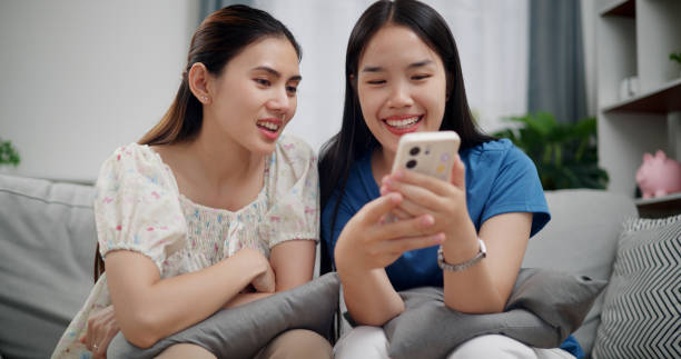 istock Two siblings are watching a funny video clips together on mobile phone. 2176295225