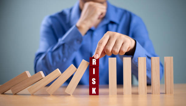istock Risk management crisis concept. Financial analysis solution for real estate business. Hand stop economic risk. Risk word on wooden block, domino crisis reduce effect. Insurance security assessment 2176313073