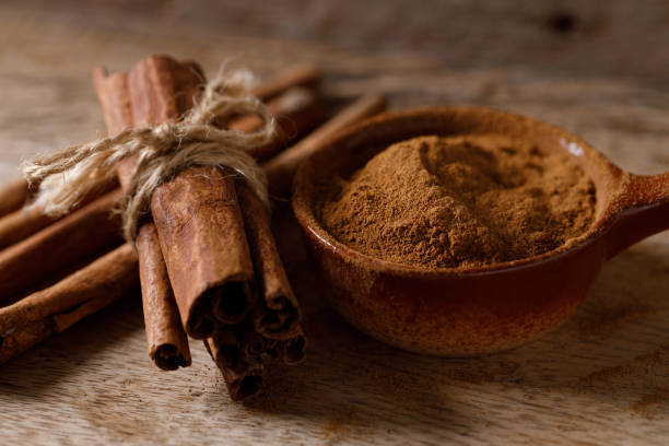 istock Aromatic cinnamon sticks and powder on wooden table. 2176313229