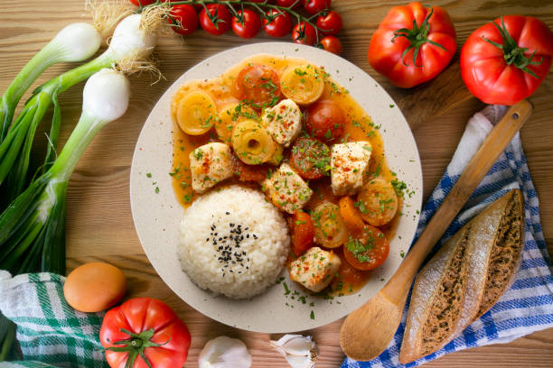 istock White fish stew with leeks and cherry tomatoes served with rice. Top view table with  decoration. 2176322063