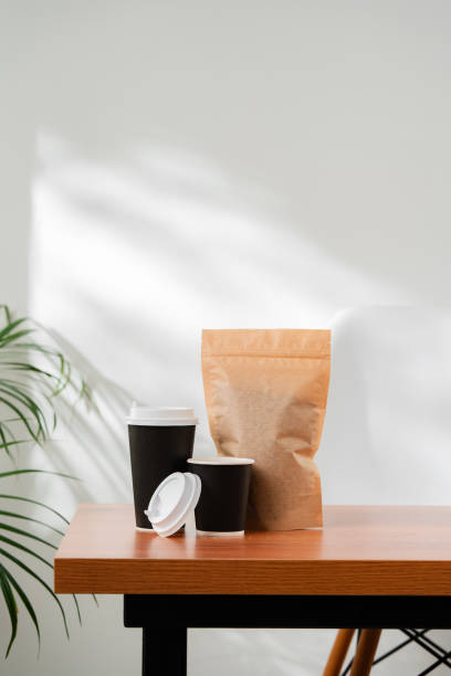 istock Three beverage containers and a paper bag on a wooden table 2176323229
