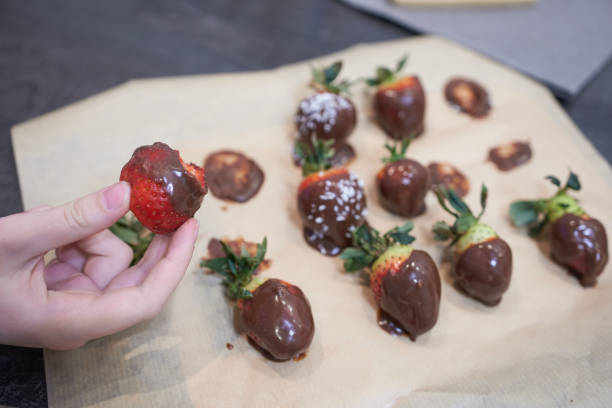 istock Chocolate-covered strawberries in a child's hand. 2176325889
