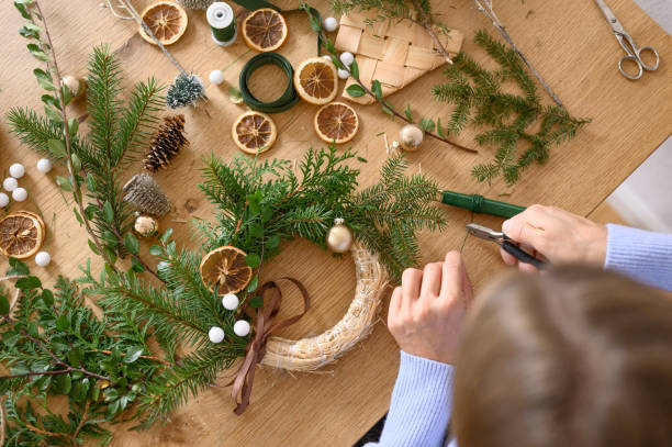 istock Person arranging decorations for a natural Christmas wreath 2176326780