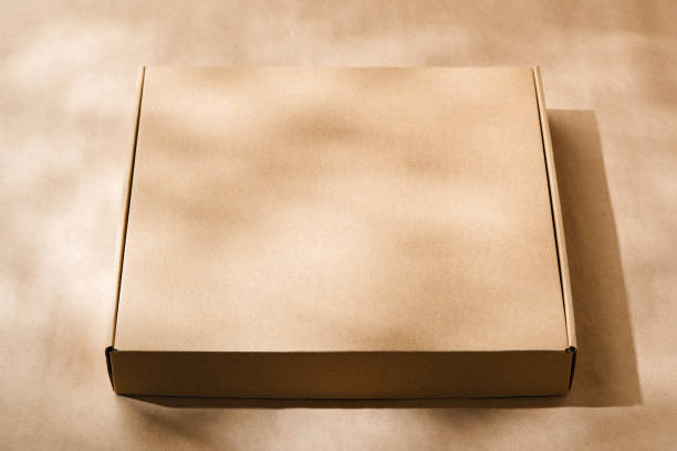 istock A plain cardboard box on a textured surface with soft light and shadows during the afternoon 2176327691