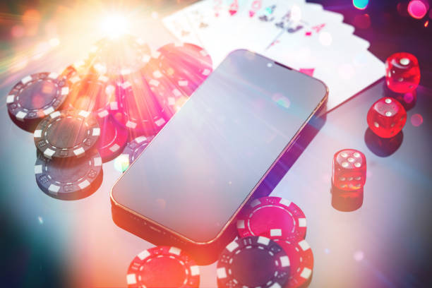 istock A smartphone rests beside poker chips, dice, and playing cards on a black surface in an intimate gaming setup at night 2176327906