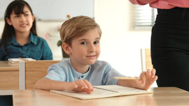 istock Boy looking at blackboard while diverse student learning at school. Pedagogy. 2176328118