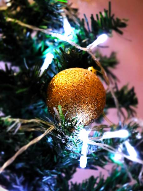 istock gold glitter christmas ball in christmas tree light 2176329761