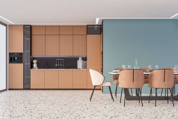 istock Modern camel brown kitchen with a full dining table, and beige and camel brown leather chairs in front of an empty light grayish blue wall with copy space, on terrazzo floor, a large window on a side stock photo 2176330084