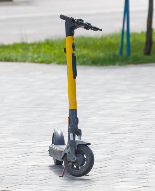 istock A yellow and black scooter is parked on a sidewalk 2176330907