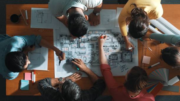 istock Top down view of engineer team writing at blueprint at meeting table. Symposium. 2176332427