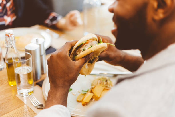 istock Afro american eating burger in a restaurant 2176339963