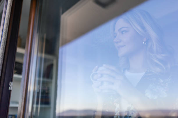 istock Woman looking through the window 2176340571