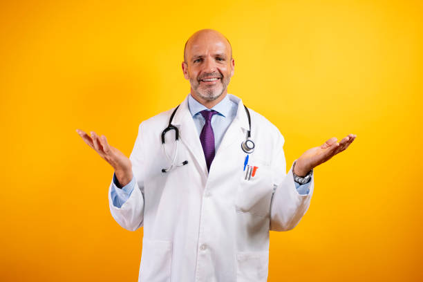A doctor smiling with arms outstretched and palms up.
