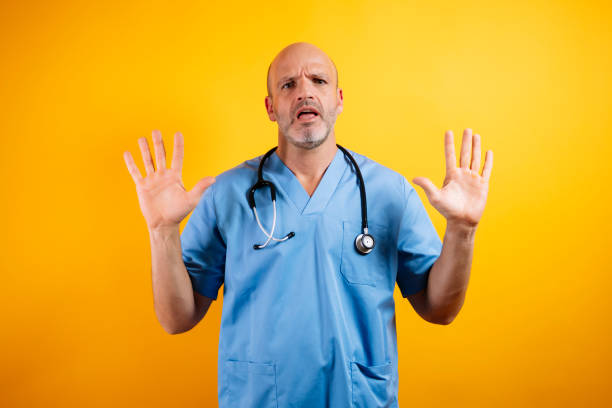 istock A doctor is shown with his hands raised in a gesture of caution. 2176341377