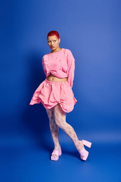 istock A young woman with pink short hair showcasing her bold style in a studio setting 2176341469