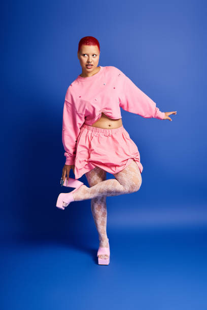 istock A young woman with pink hair expresses her bold style in a vibrant studio setting 2176341644