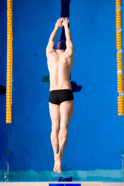 male professional competitive swimmer in swimming pool.