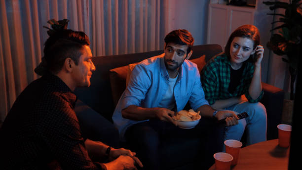 istock Father and mother watching movie while eating snack with friend. Convocation. 2176344579
