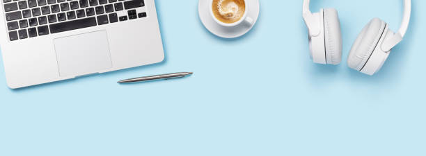 istock Laptop, headphones, and coffee cup arranged on a blue background 2176345947