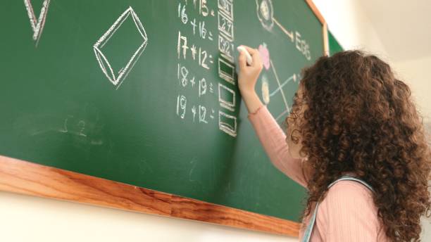istock Back view of african student answer question while writing at board. Pedagogy. 2176346089
