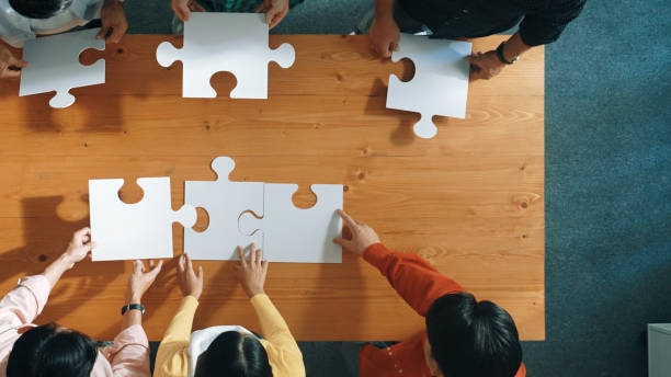 istock Top down view of business people assemble jigsaw puzzle on table. Convocation. 2176346343