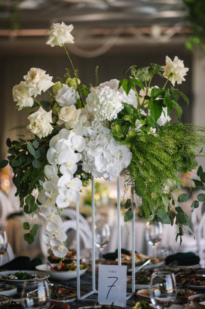 istock Table number 7. Stands, sign number seven. Setup detail. Luxury reception. Elegant table decorated composition flowers in party area. Beautifully organized event. Wedding hall with atmospheric decor. 2176348063