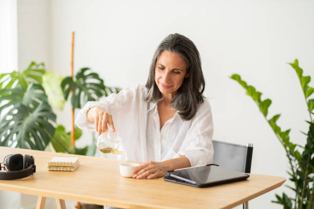 istock Casual businesswoman drinking tea during work break at home 2176348168