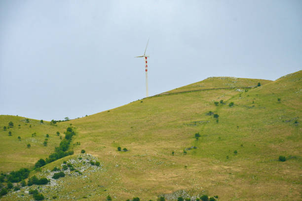istock Wind turbine on the mountain ridge with cloudy sky 2176349584