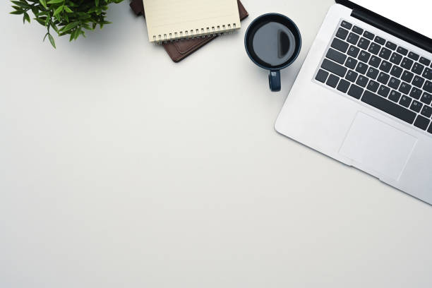 istock White office desk with laptop, coffee cup, notepad and potted plant. Top view, Flat lay 2176351873