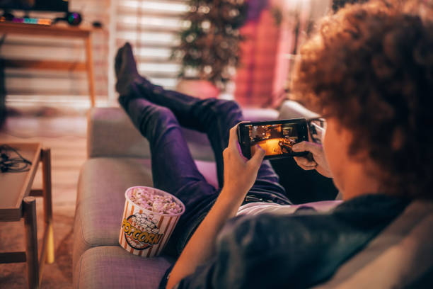 istock Teenage boy playing mobile game at home 2176352645
