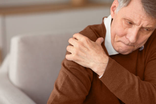istock Senior Gentleman Having Shoulder Pain Sitting On Couch 2176353104