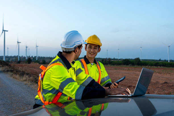 istock Diverse ethnicity male technicians working in the wind turbines field. Innovation engineer men use laptop computer work to develop environmental renewable clean energy outdoors at windmill power farm. 2176353326