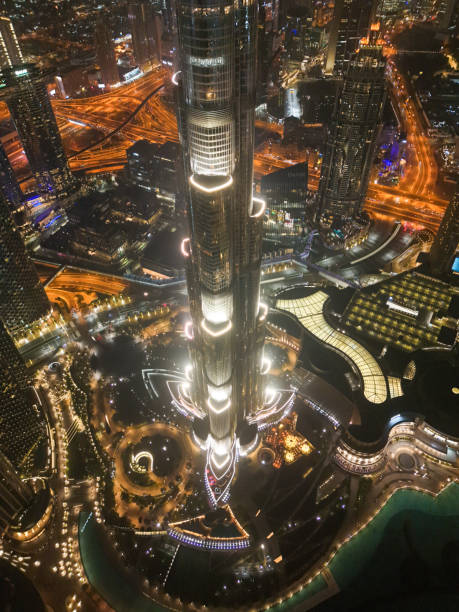 Spectacular aerial night view of Dubai, illuminated with lights, surrounded by the city's vibrant roads and architecture.